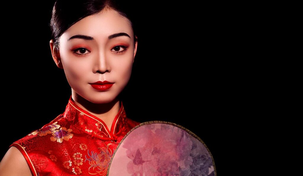En japansk geisha - en vakker kvinne i rød kimono.